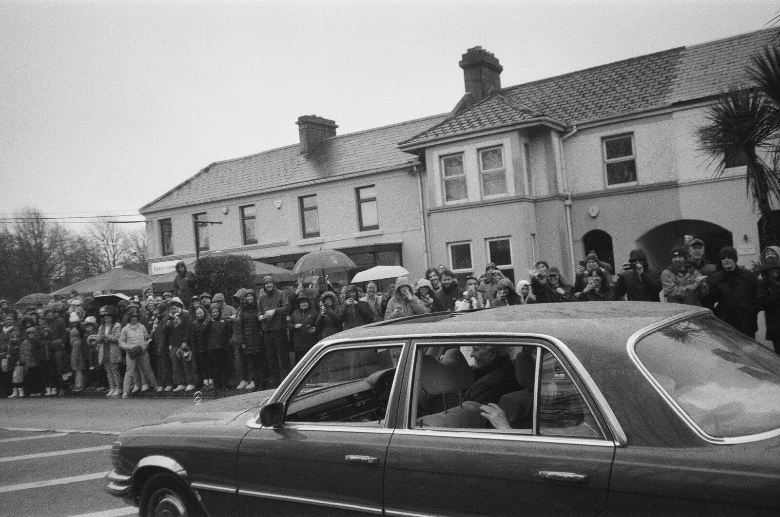 a presidential motorcade passing a crowd in galway